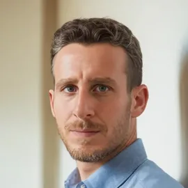 Ron Gold, founder of A-Eye Level: portrait of a man with short brown hair and a trimmed beard, wearing a light blue shirt